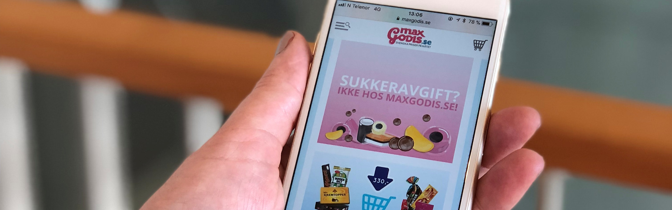 Nærbilde av en mobiltelefon som har nettsiden til MaxiGodis åpen i nettleseren