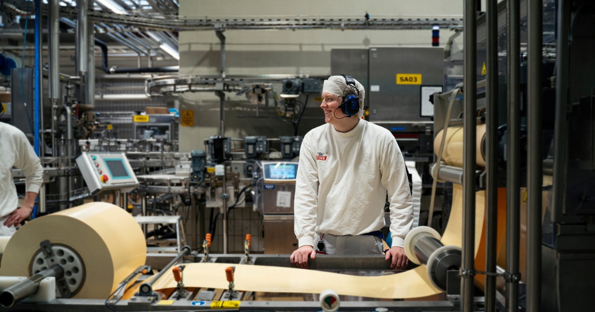 Person som står ved en pakkemaskin.