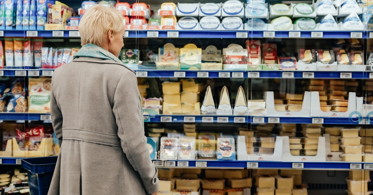 Kunde foran ostedisk i dagligvareforretning.